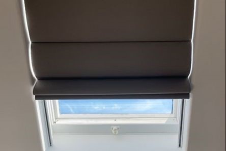 Close-up of electric custom skylight shades partially open, showing natural daylight filtering through automated window coverings in a Beverly Hills hall.