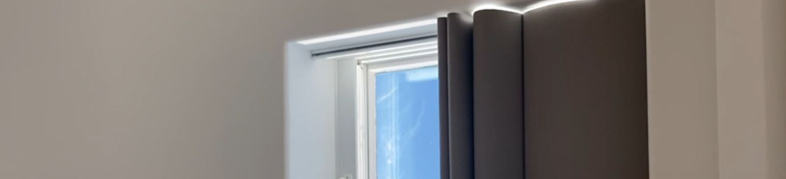 Close-up of electric custom skylight shades partially open, showing natural daylight filtering through automated window coverings in a Beverly Hills hall.