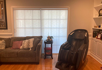 Dining room featuring roller window shades, casting a soft glow of light into the room.